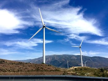 Low angle view of windmill on field against sky