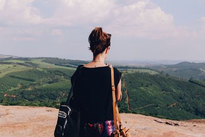 Rear view of woman standing on landscape