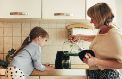 Side view of couple holding hands at home