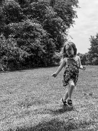 Portrait of young girl running on field