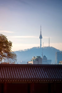 View of communications tower and buildings against sky