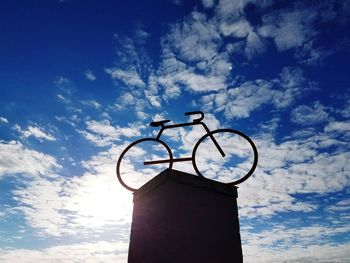 Low angle view of bicycle against blue sky