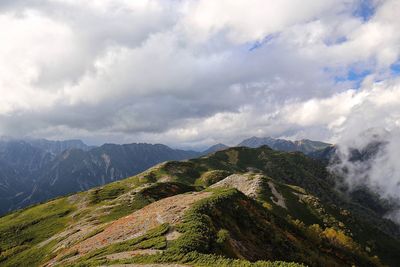 Scenic view of mountains against cloudy sky