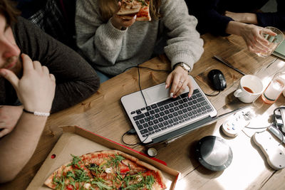 High angle view of business colleagues eating pizza at workplace