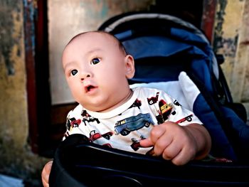 Close-up of cute toddler in baby carriage