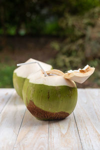 Fresh coconut on a wooden table with natural backdrop