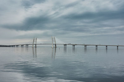 Bridge over calm sea against sky