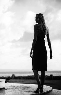 Rear view of woman standing on beach