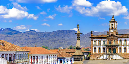 Buildings in city against cloudy sky