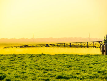 Scenic view of field against clear sky during sunset