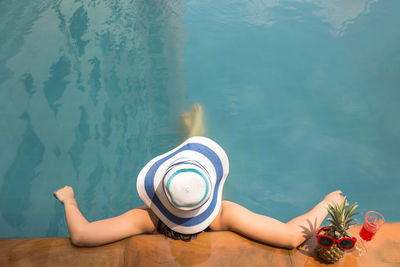 Woman wearing hat while relaxing in swimming pool