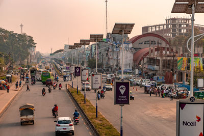 Vehicles on city street against sky