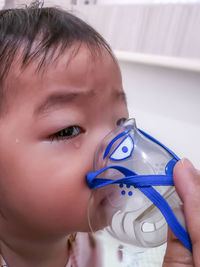 Close-up portrait of cute boy holding camera