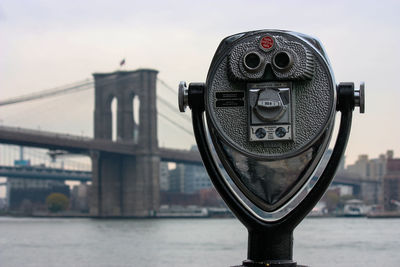 Close-up of coin-operated binoculars against cityscape