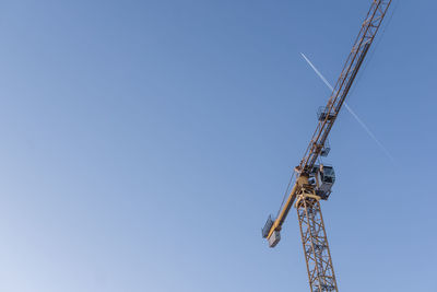 Low angle view of crane against clear sky