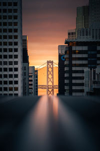 Modern buildings against sky during sunset