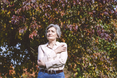 Portrait of smiling woman standing against plants