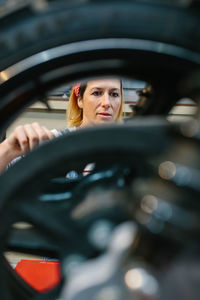 Mechanic woman repairing motorcycle disk brake on factory