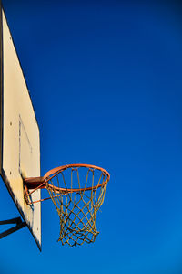 Low angle view of basketball hoop against blue sky