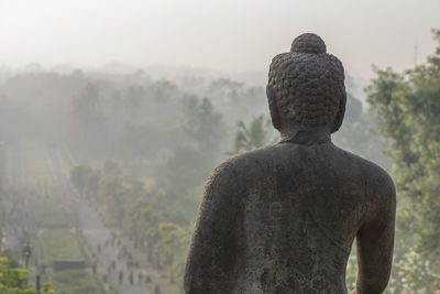 Rear view of statue against temple