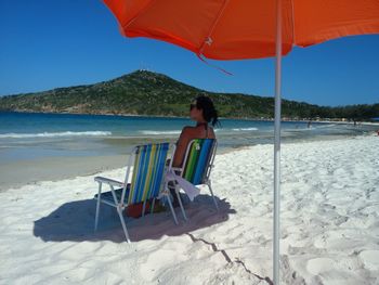 Woman sitting on chair at beach