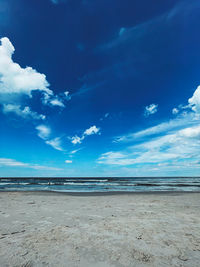 Scenic view of beach against blue sky