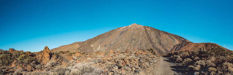 Scenic view of rocky mountains against clear blue sky