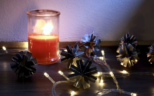 Close-up of illuminated tea light candles on table