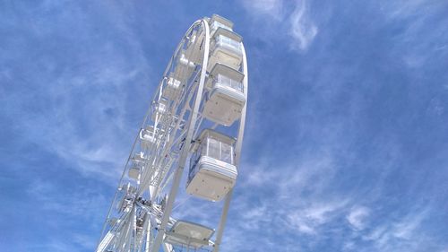 Low angle view of ferris wheel and buildings against sky