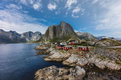 Scenic view of houses by mountains against sky