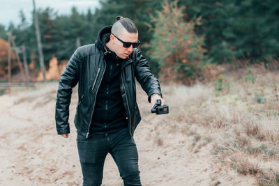 Full length of young man wearing sunglasses standing on land