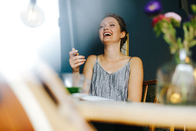 Smiling young woman sitting at cafe