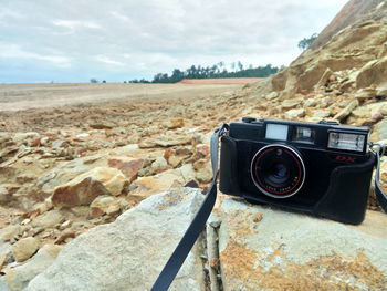 View of camera on desert land against sky