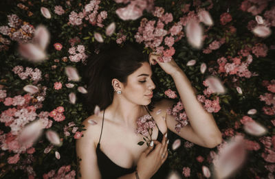 Portrait of beautiful woman with pink flowers and petas