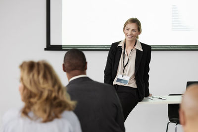 Business people sitting and listening to businesswoman