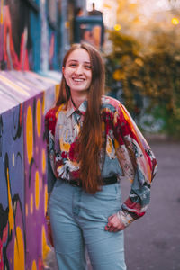 Portrait of smiling young woman standing outdoors