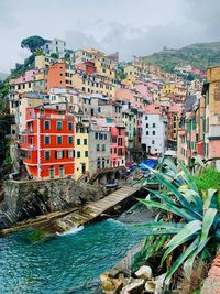 Houses by sea against buildings in city