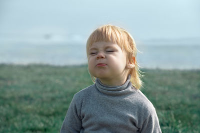 Cheerful cute girl making face outdoors