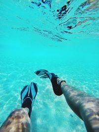 Low section of man swimming in sea