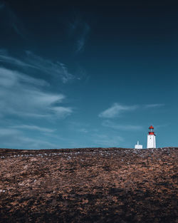 Lighthouse by sea against sky