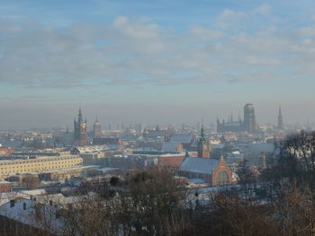 High angle view of city buildings against cloudy sky