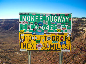 Close-up of signboard against rock formation