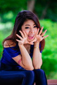 Portrait of a smiling young woman sitting outdoors