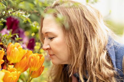A middle-aged woman sniffs and admires tulips in the botanical garden.spring.