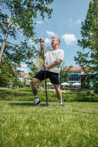  view of man standing on grassy field singing all loud 