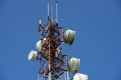 Low angle view of communications tower against clear blue sky