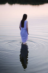 Rear view of woman standing in lake