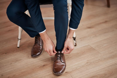 Low section of man standing on hardwood floor