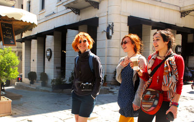 Young women walking with coffee cup at sunlight day in the street of istanbul, turkey. happy faces 