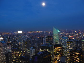 Illuminated buildings in city against sky at night